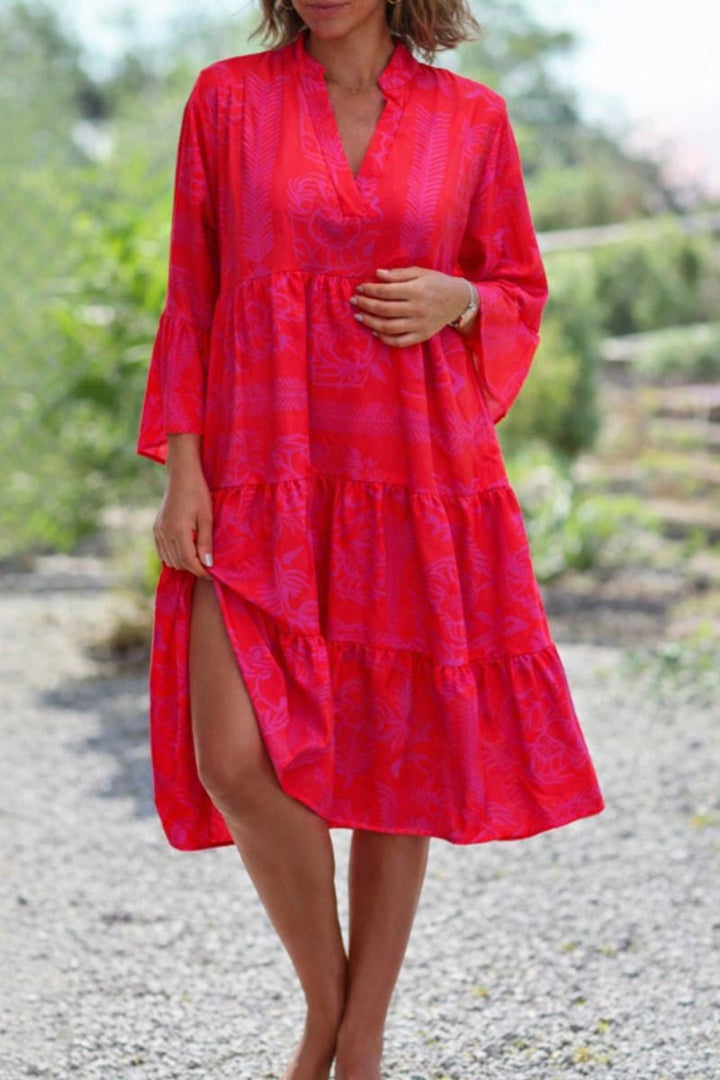 Woman wearing a flowing boho dress on a plain background.