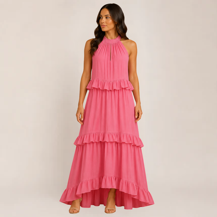 Female model wearing a lightweight tiered dress with delicate straps on a plain background.