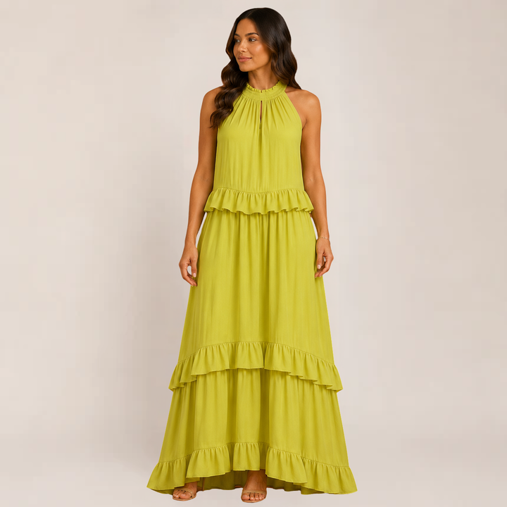 Woman posing in a breezy ruffle maxi outfit with a feminine silhouette on a plain background.
