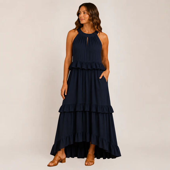 Female model in a soft layered summer dress styled with spaghetti straps on a plain background.