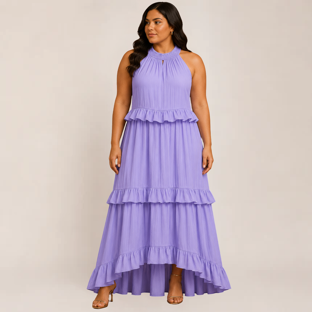 Woman in a layered ruffle maxi dress styled for warm weather on a plain background.