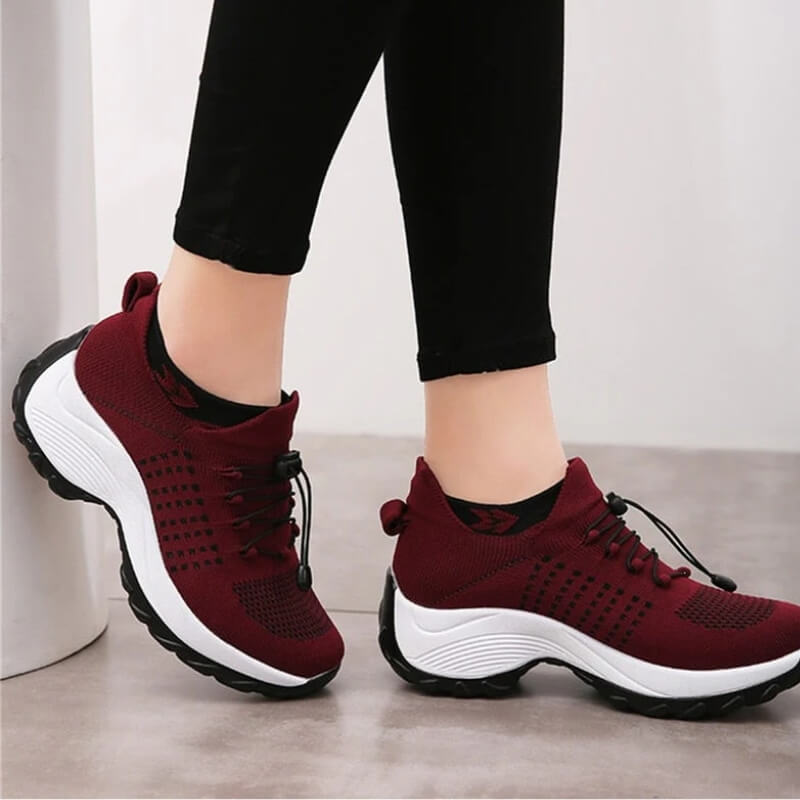 Female model wearing casual walking shoes on a plain background.