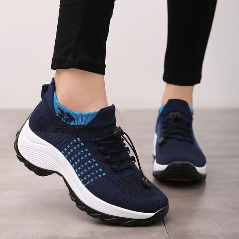Woman standing in comfort walking shoes on a plain background.
