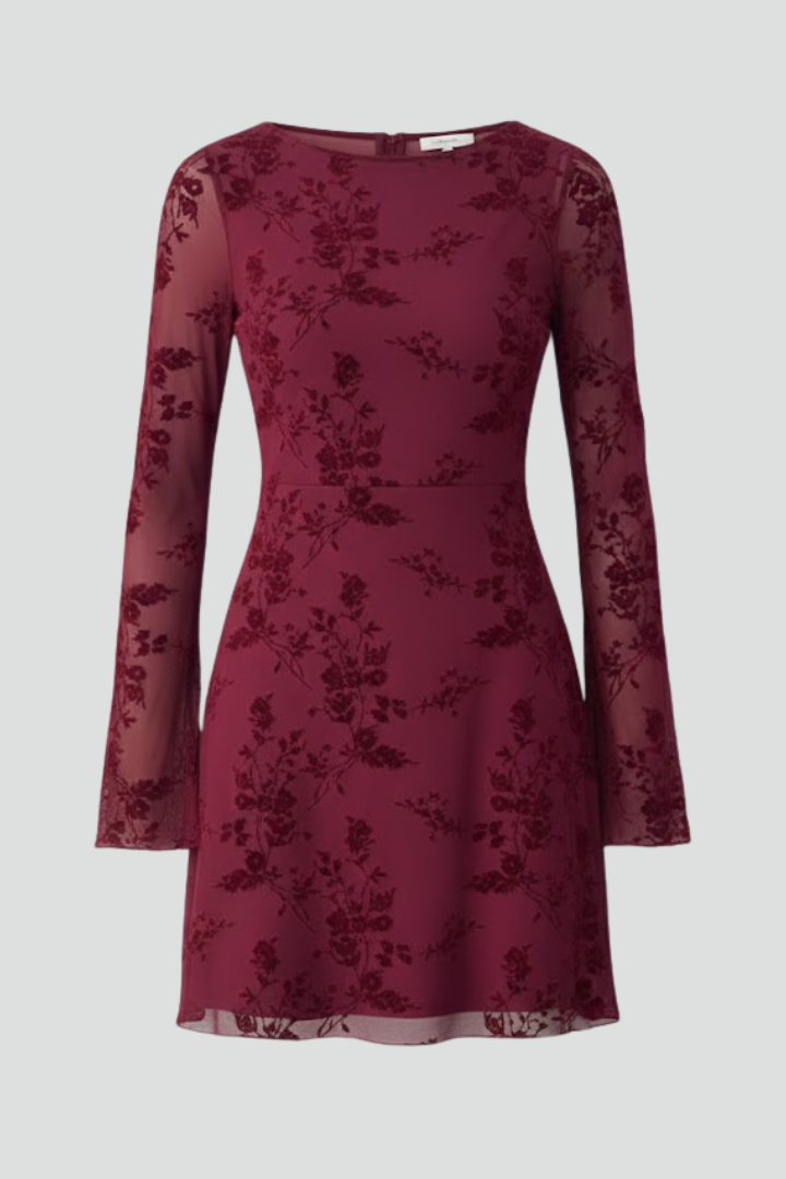 A floral mesh mini dress with long sleeves against a plain background.