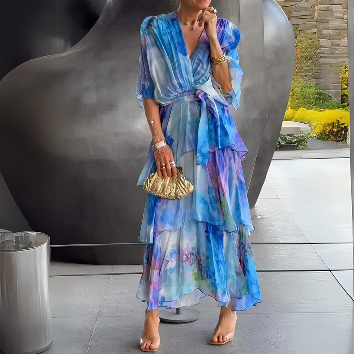 Female model wearing a V-neck dress on a plain background with a graceful fitted silhouette.