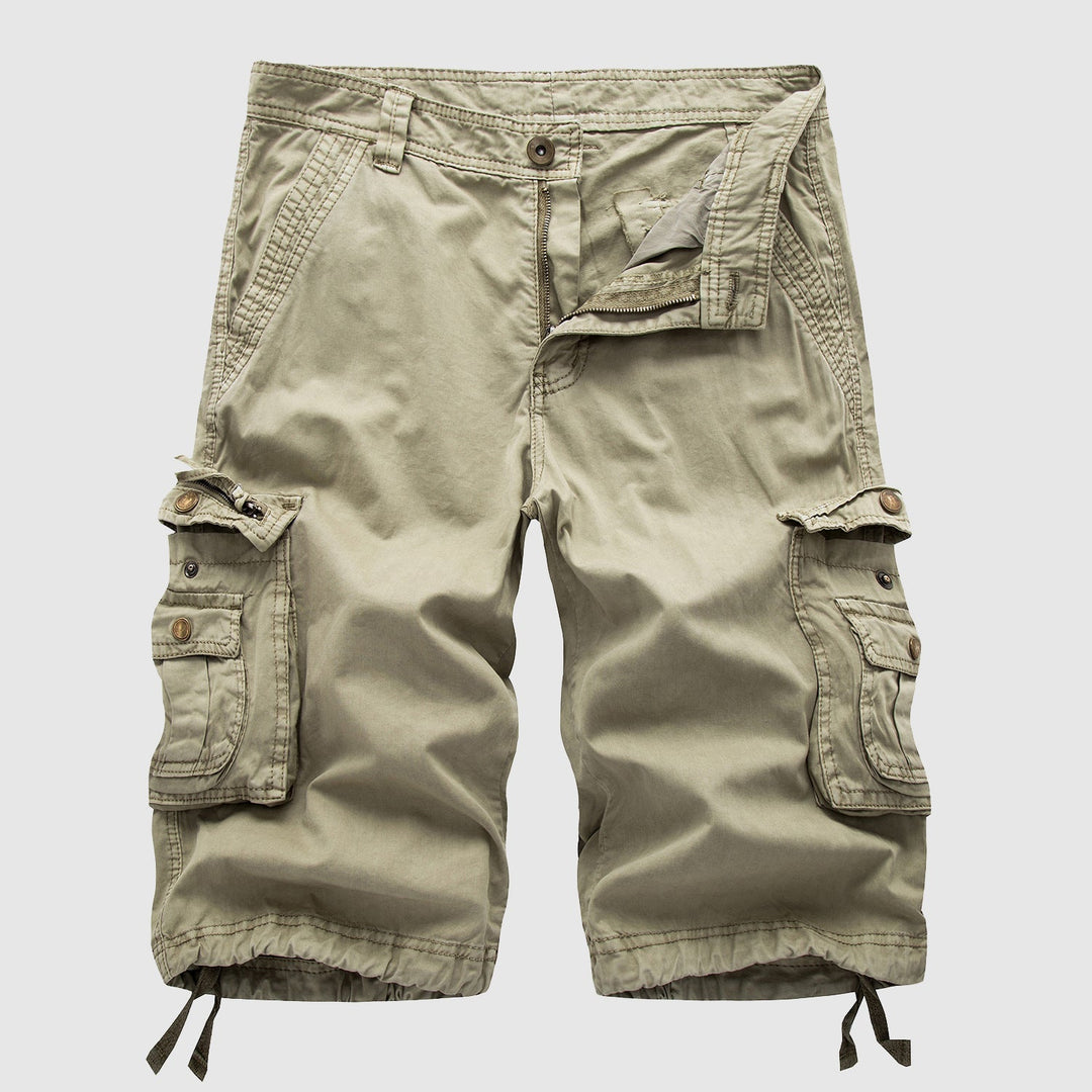 Male model wearing cargo shorts with multiple flap pockets against a plain background.