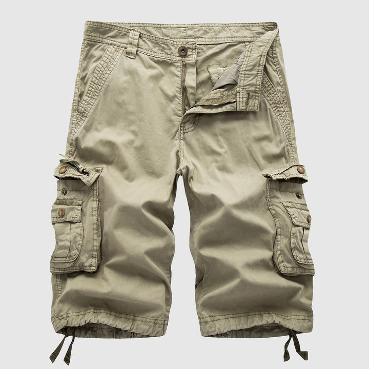 Male model wearing cargo shorts with multiple flap pockets against a plain background.