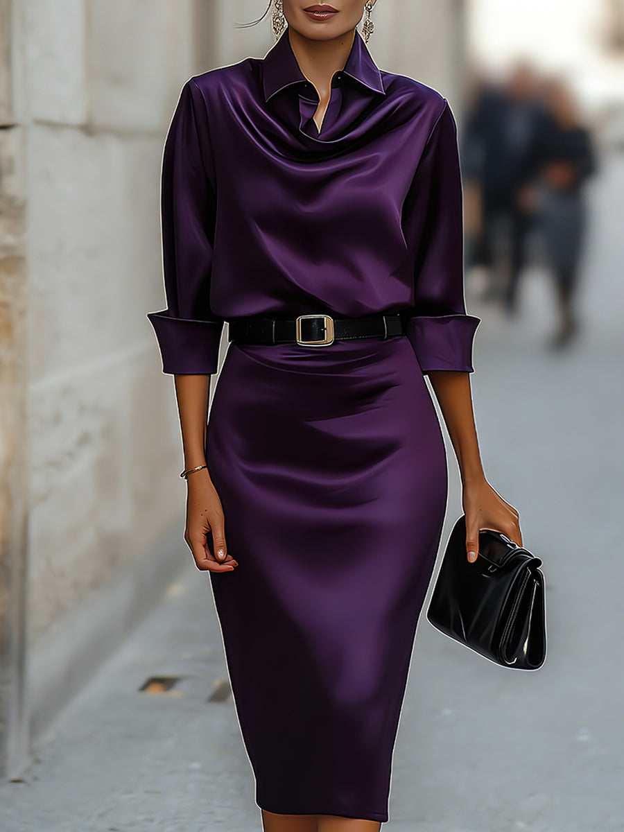 Female model in a draped collar midi dress with a defined waist on a plain background.