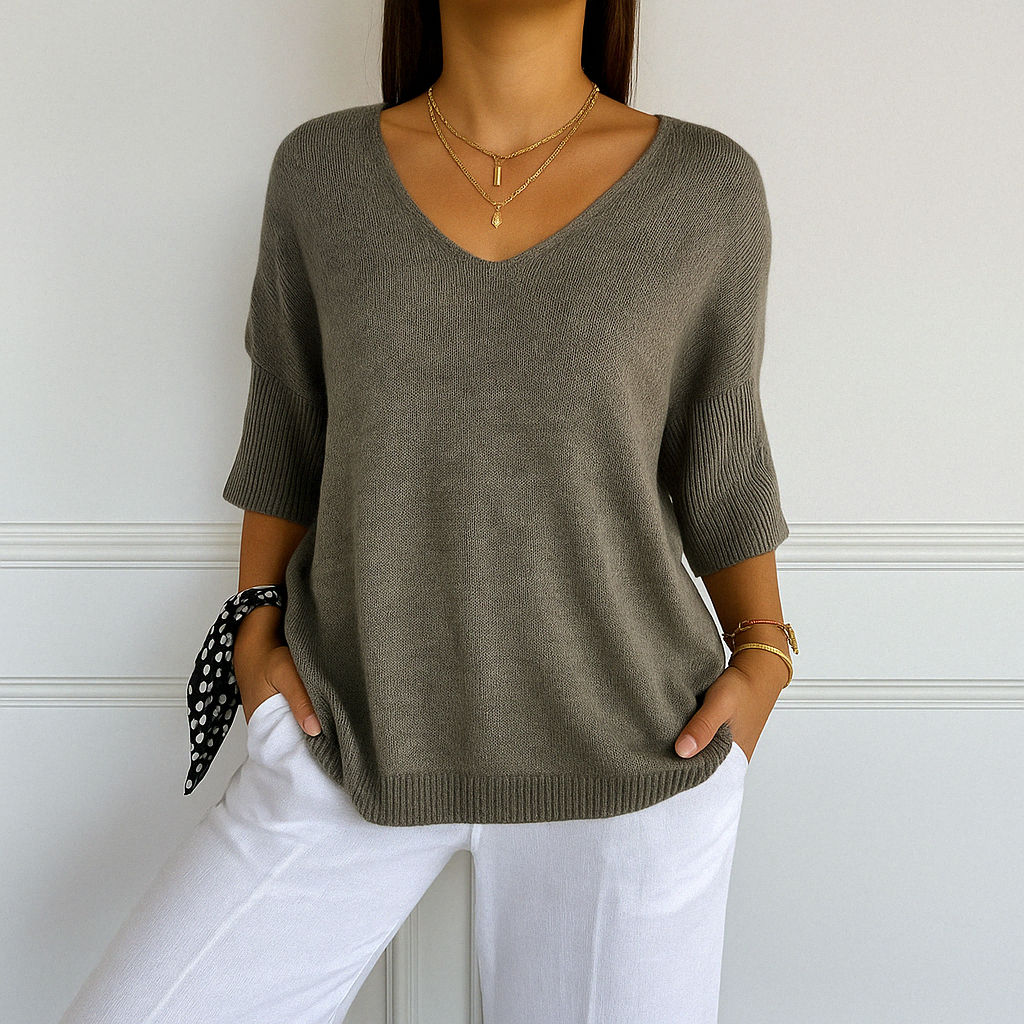 Front view of fine knit V-neck sweater on plain background.