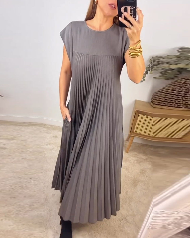Female model wearing a flowing evening maxi dress with pleated detailing.