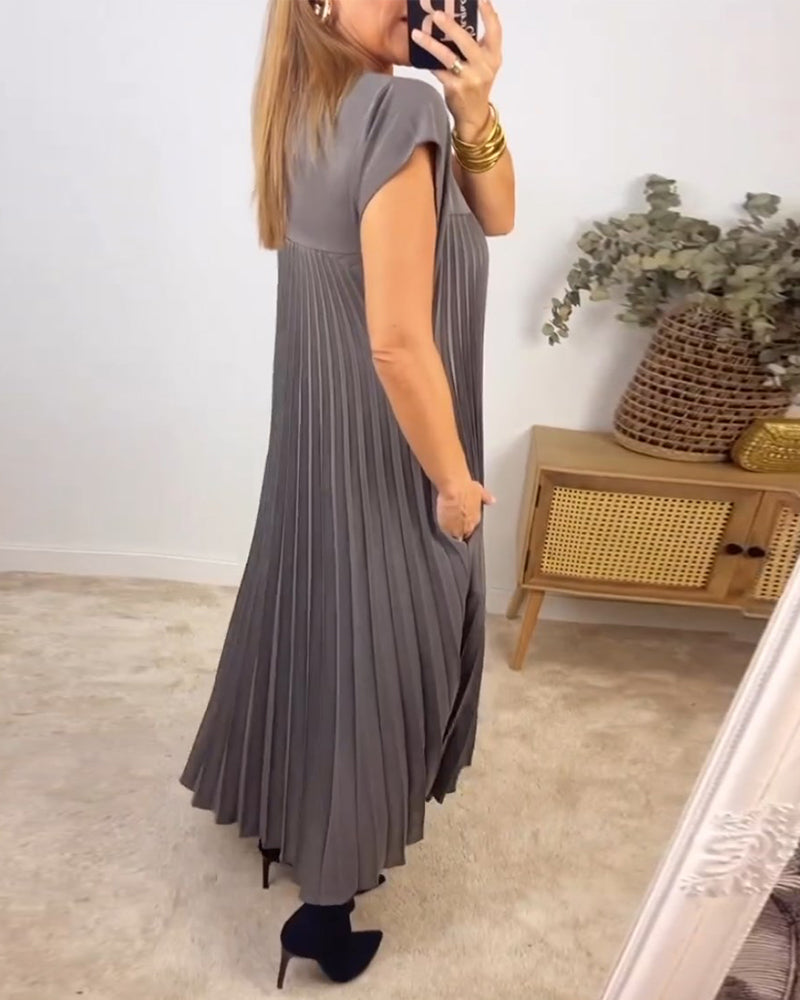 Sleeveless pleated maxi dress styled on a woman in a minimal setting.