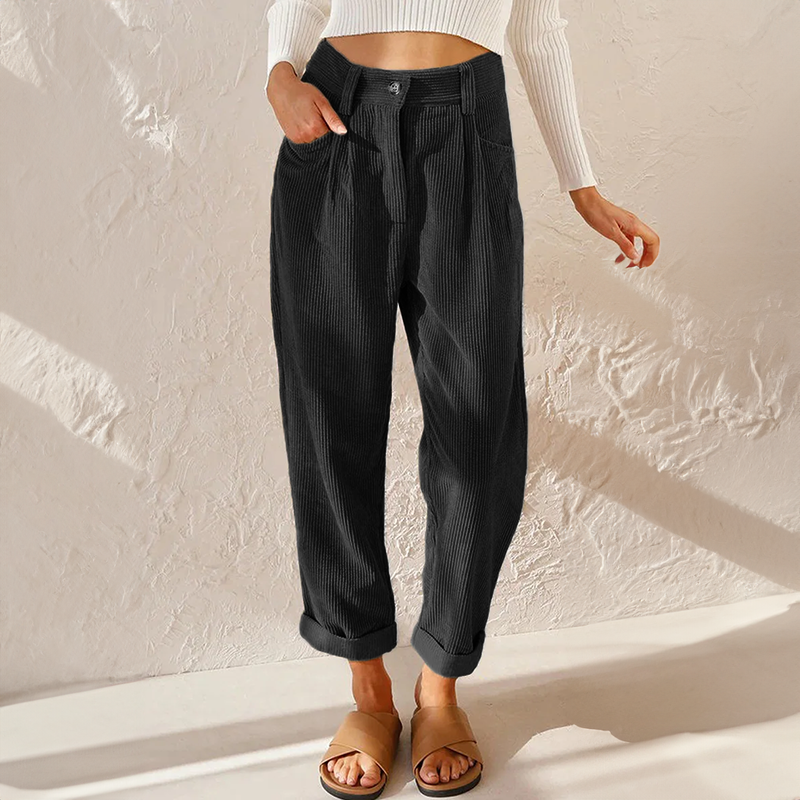 Female in relaxed fit ankle-length trousers against a plain background.
