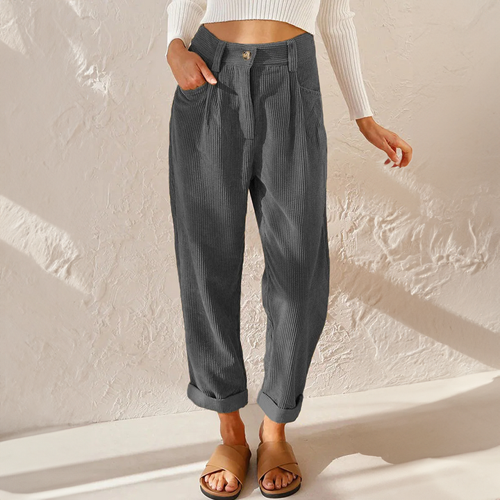 Woman wearing vintage-inspired high-rise trousers on a plain background.