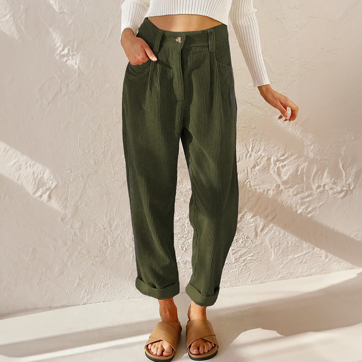 Woman modeling textured casual trousers with a tapered silhouette on a plain background.