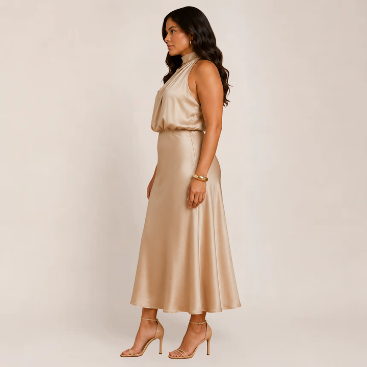 Woman in a flowing A-line formal dress against a plain background.