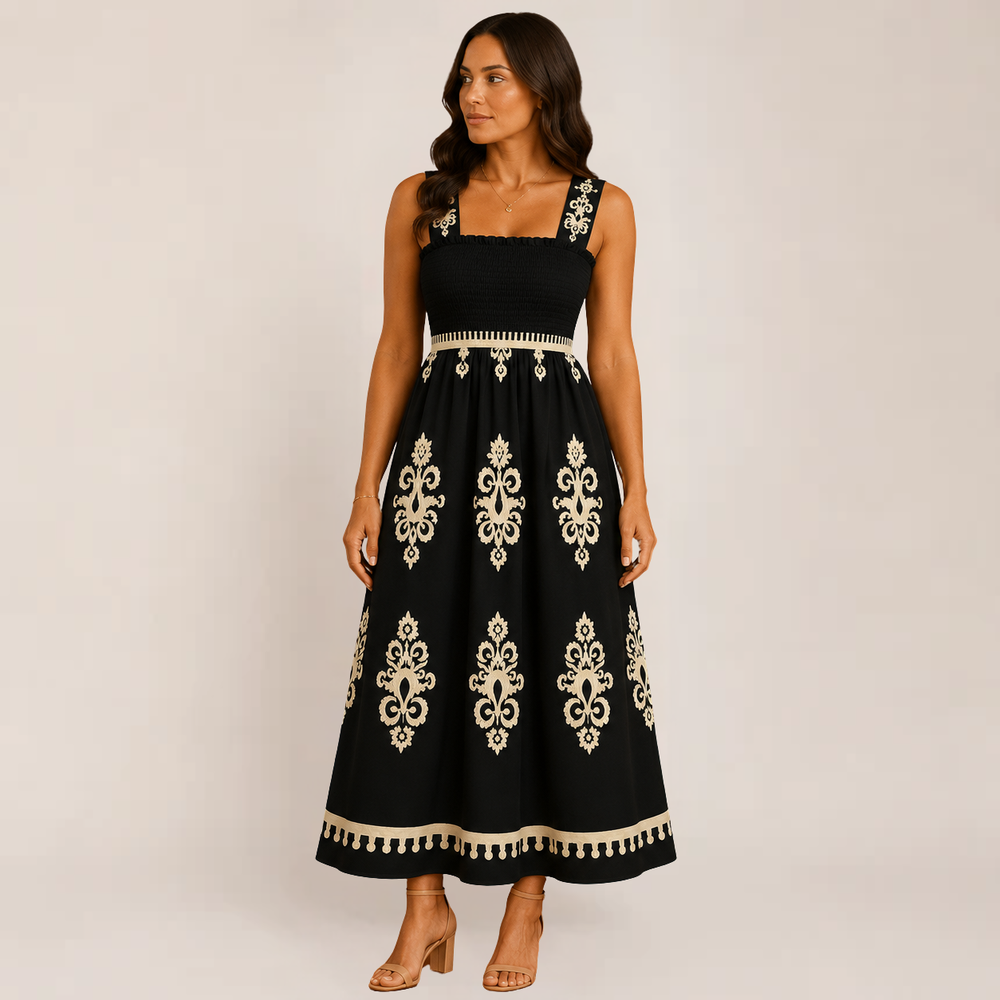 Woman wearing a long sleeveless summer dress with a soft draped silhouette on a plain background.