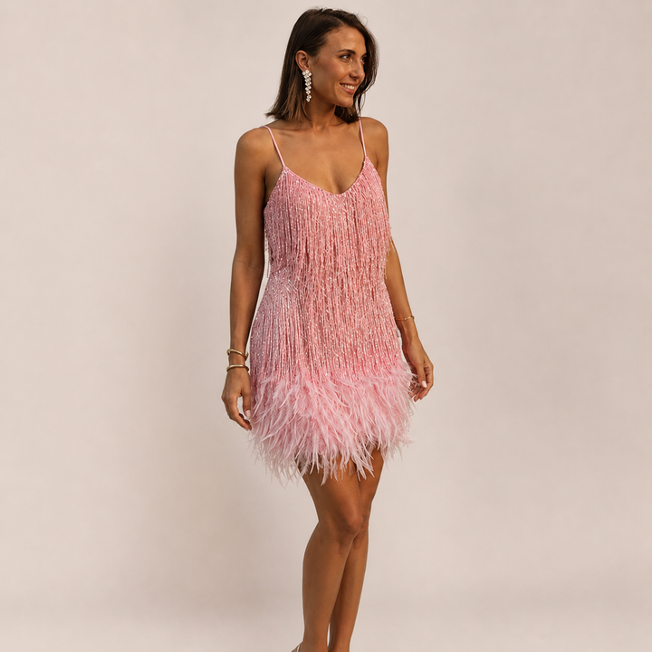 Woman posing in an evening mini dress with soft feather accents.