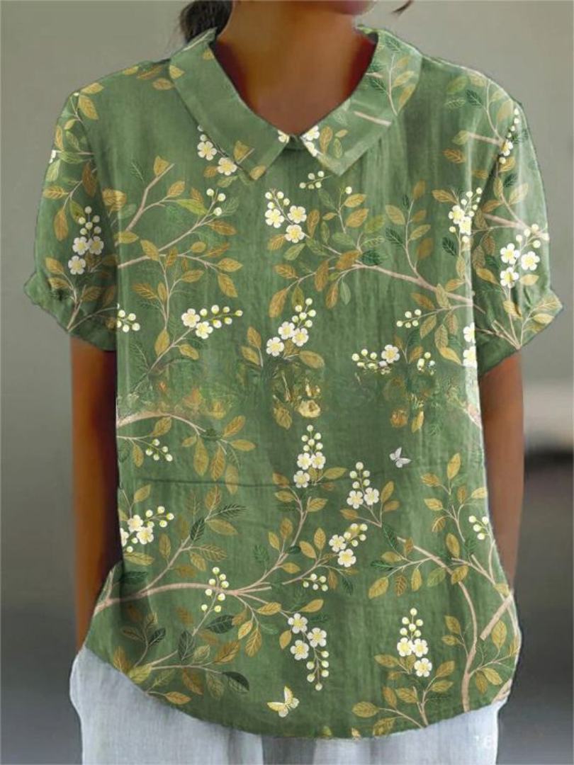 Soft-colored floral women’s shirt styled against a plain background.