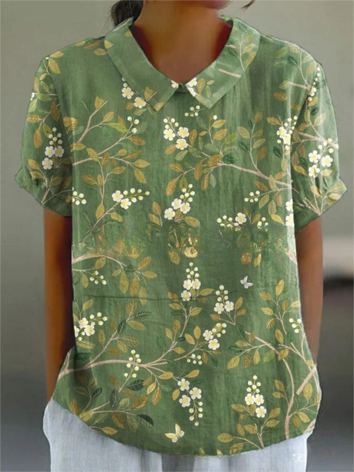 Soft-colored floral women’s shirt styled against a plain background.