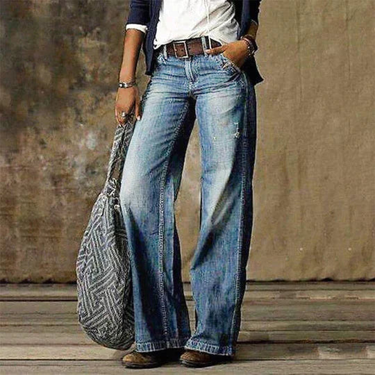 Woman wearing high waist wide leg jeans on a plain background.