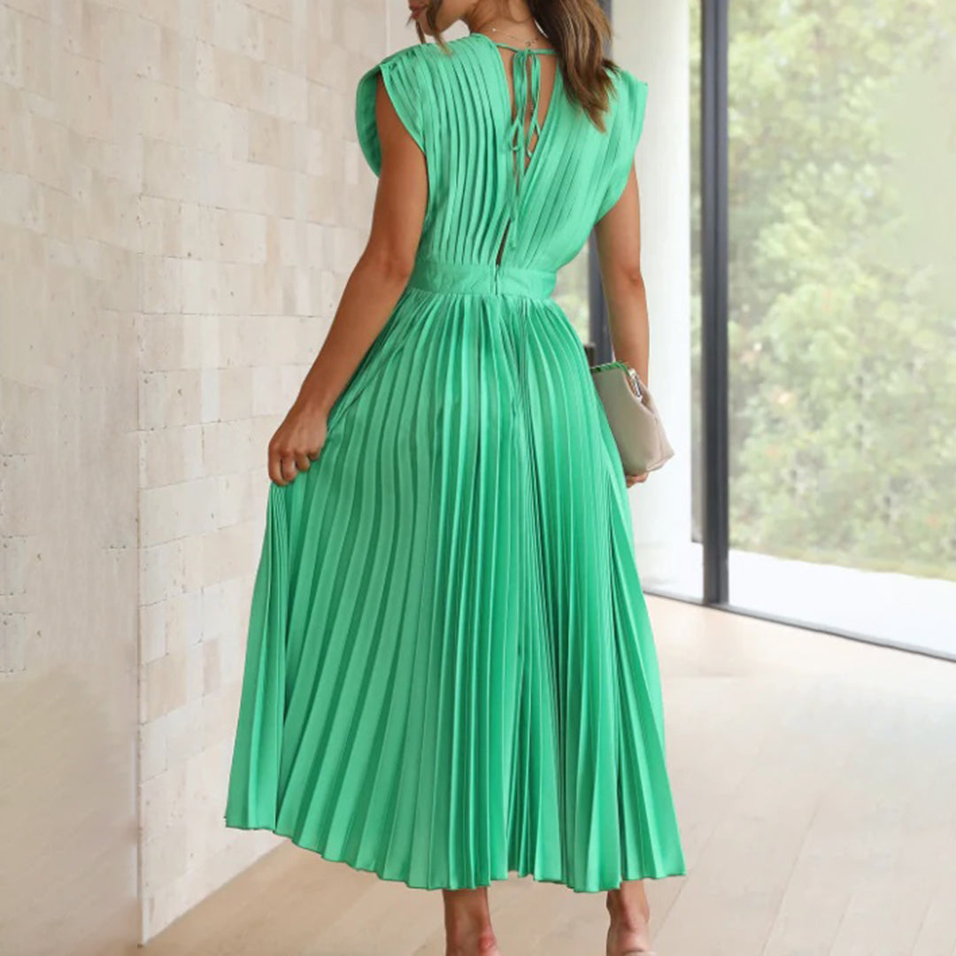 Female model in a stylish dress on a plain background, back view
