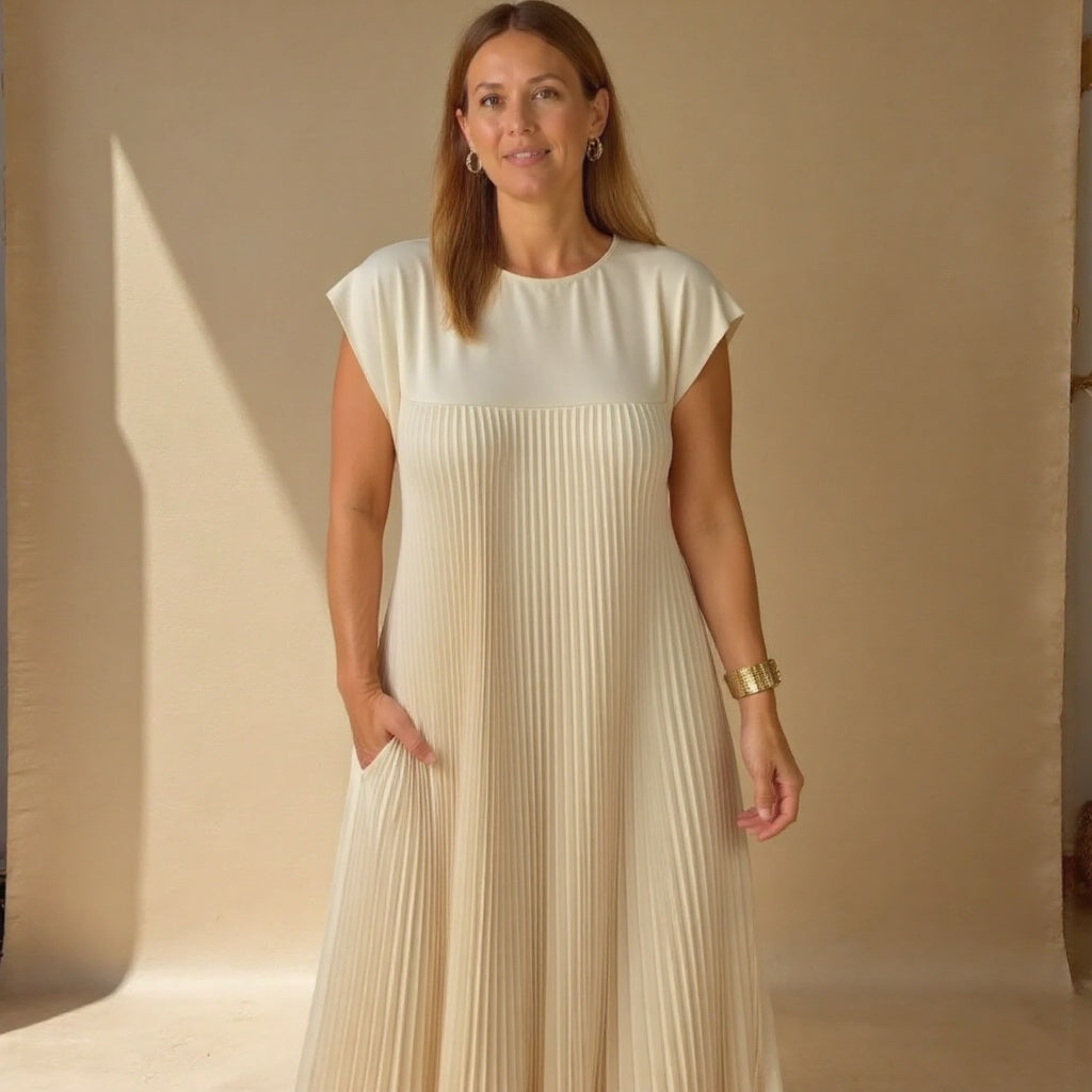 Woman wearing a flowy cocktail dress with elegant pleated accents.
