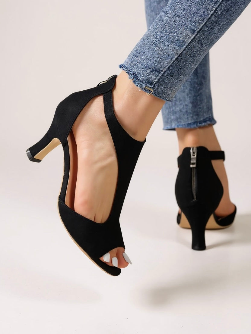 Female model wearing cutout block heel sandals on a plain background.