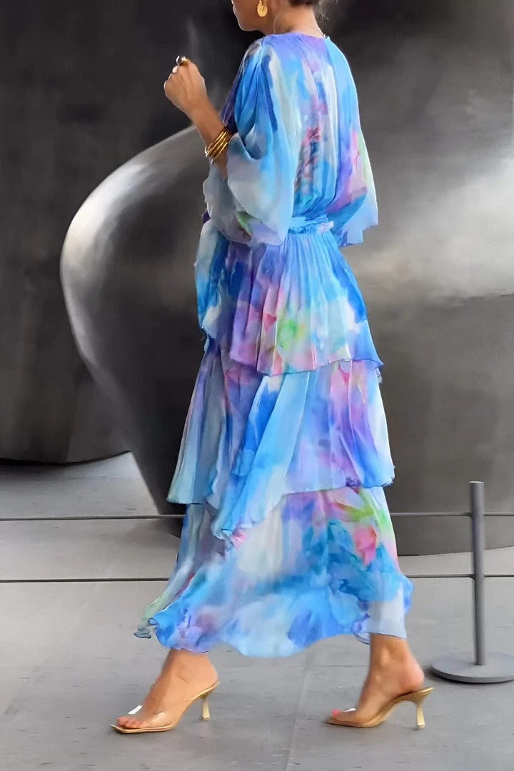 Female model showcasing a waist-defining dress with soft draping on a plain background.