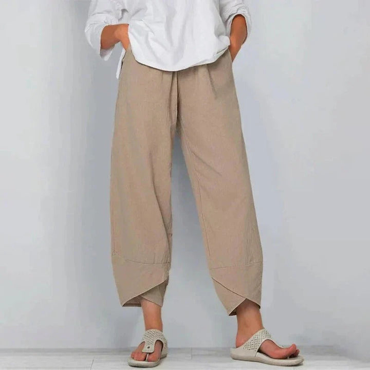 Female model wearing chic summer pants on a plain background.