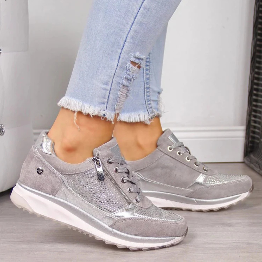 Woman wearing casual slip-on shoes on a plain background.