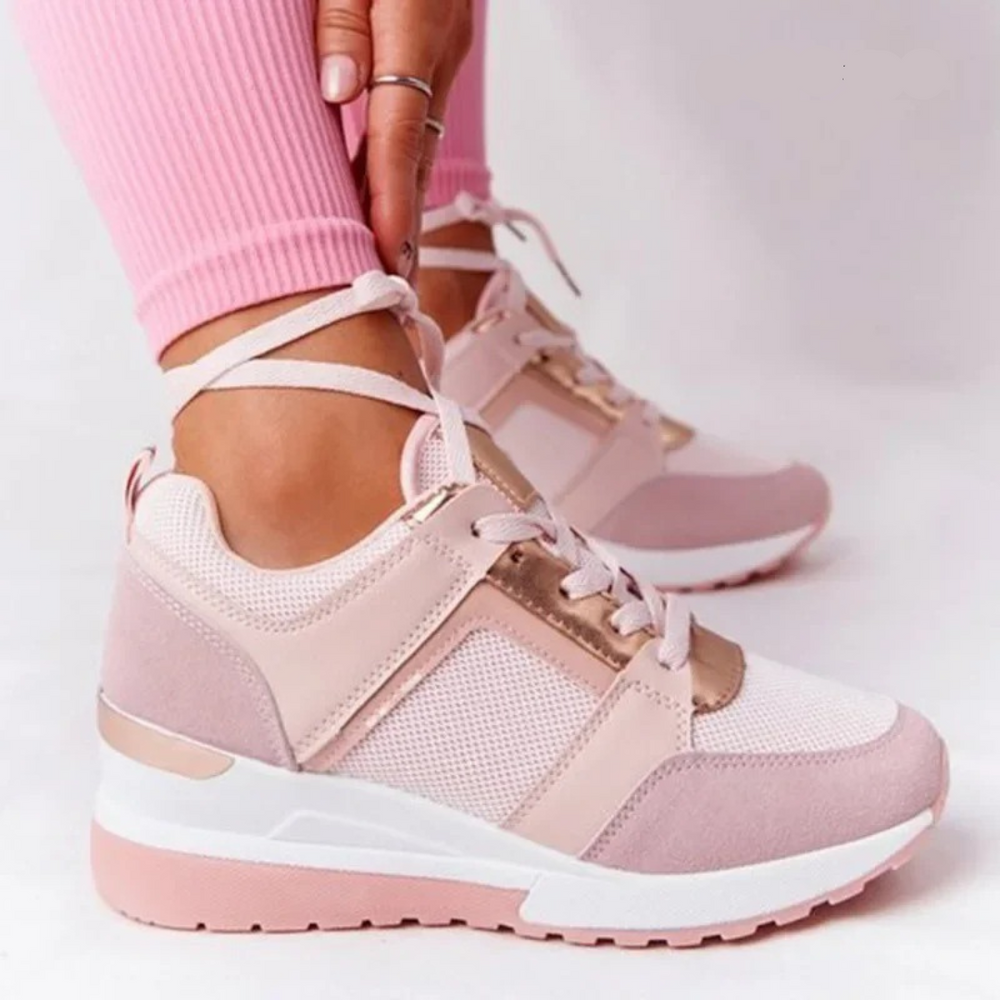 Female model showing everyday walking shoes on a plain background.