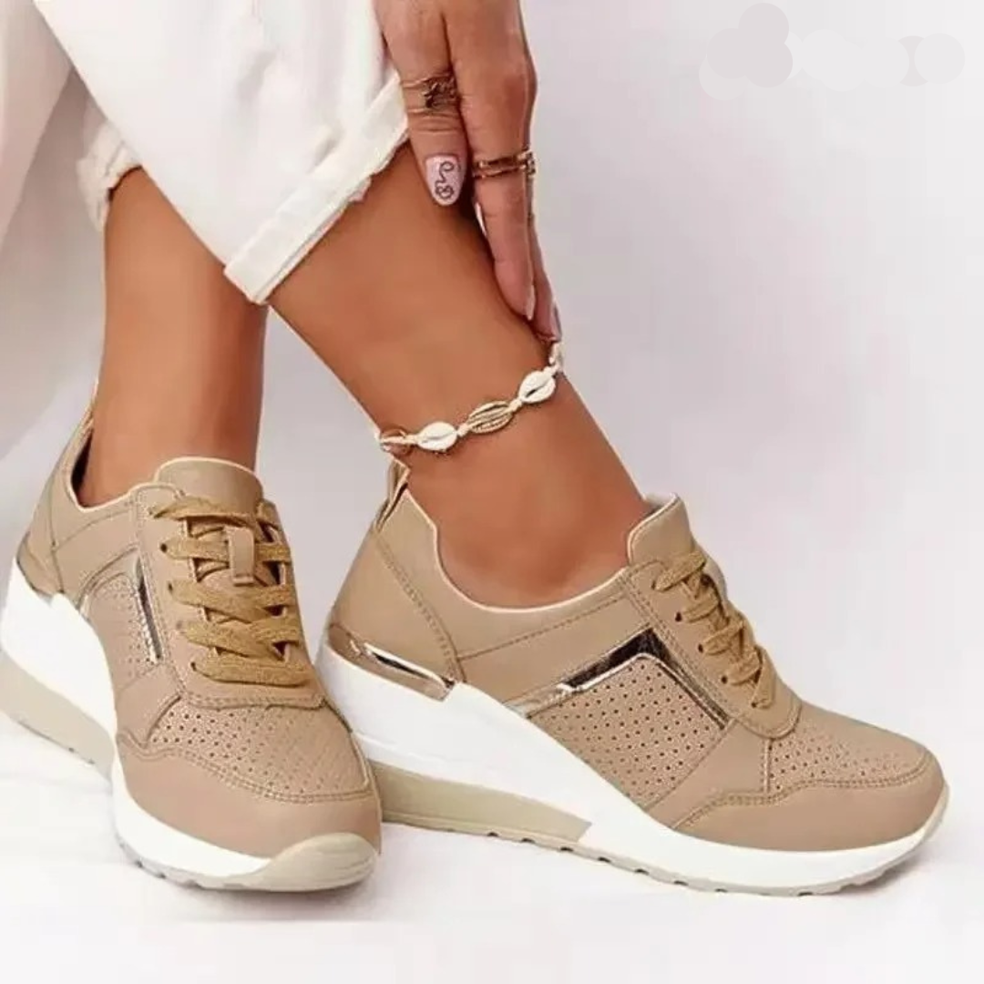 Close view of feet wearing casual shoes on a plain background.