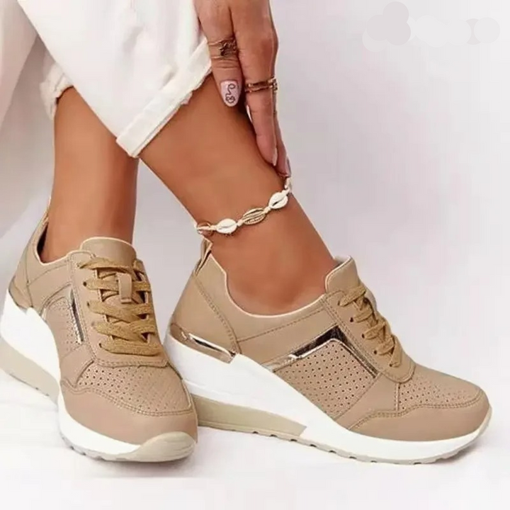 Close view of feet wearing casual shoes on a plain background.