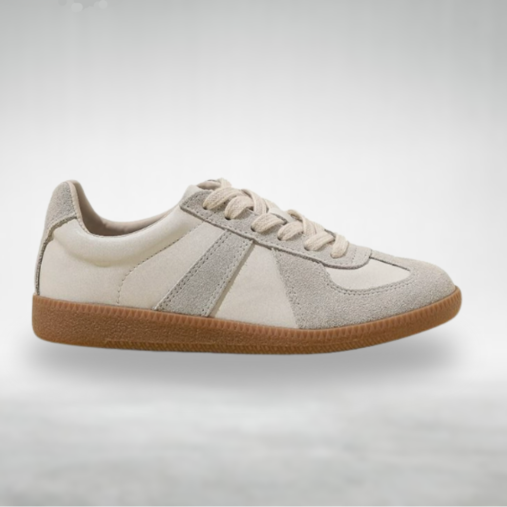 Female model wearing slip-on shoes on a plain background.