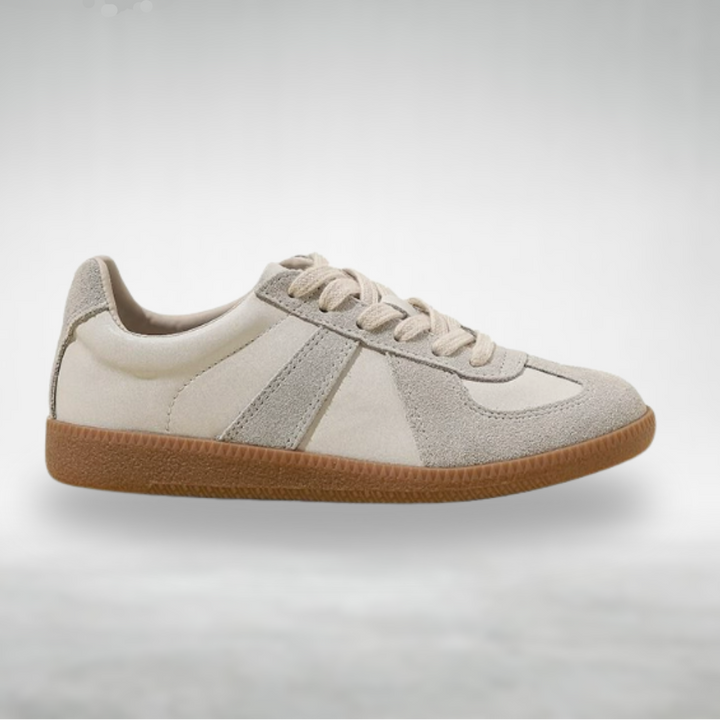 Female model wearing slip-on shoes on a plain background.