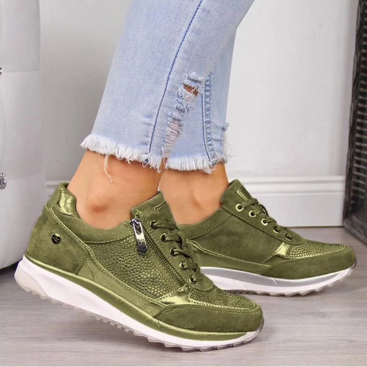Feet wearing simple women’s shoes against a plain background.