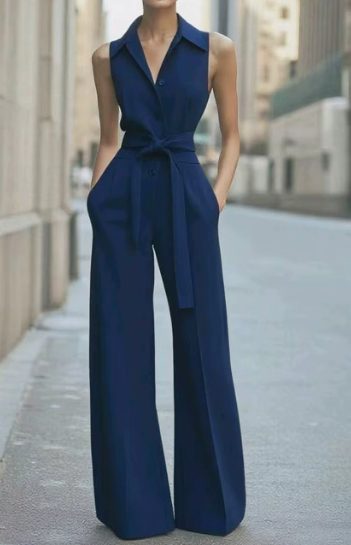  Female model showcasing a bright orange one-piece outfit with wide-leg pants on a plain background.