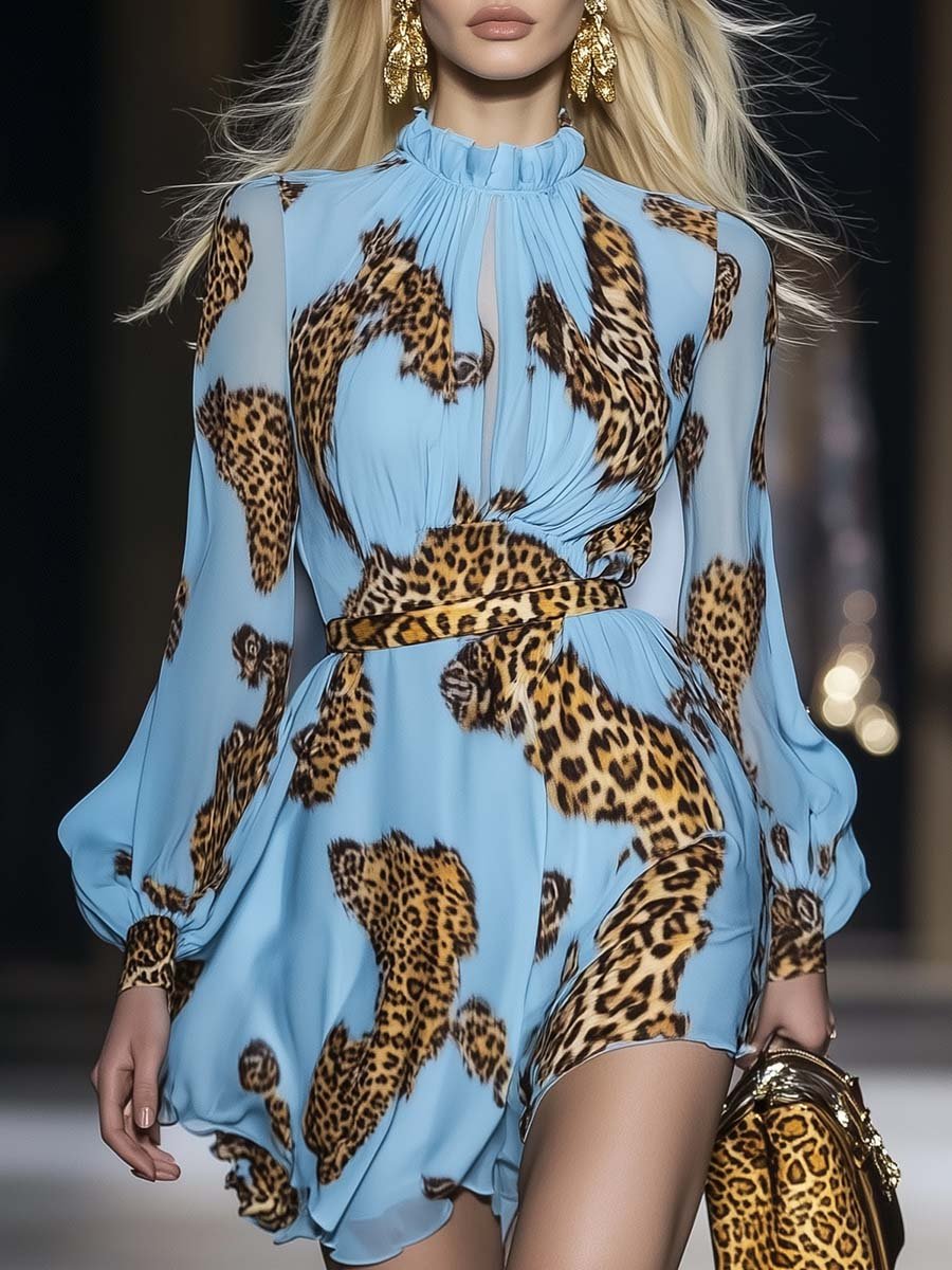 Woman posing in a flowing animal print mini dress with ruffle neckline on a plain background.
