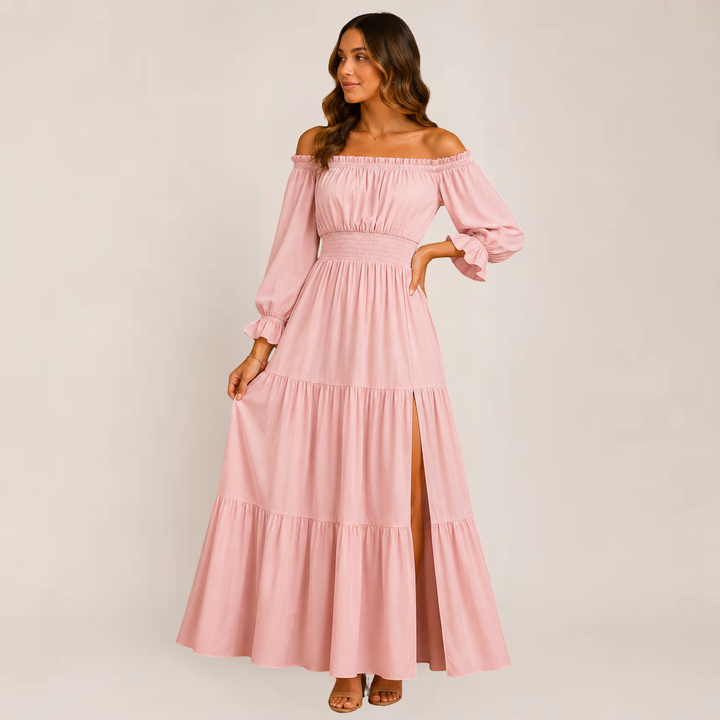 Female wearing an off-shoulder tiered dress on a plain background.