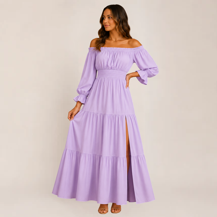 Female standing in an elegant off-shoulder dress against a plain background.