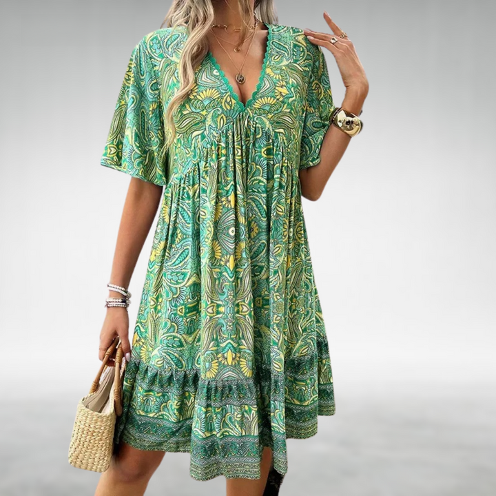 Female model posing in a stylish long dress with soft draping details.