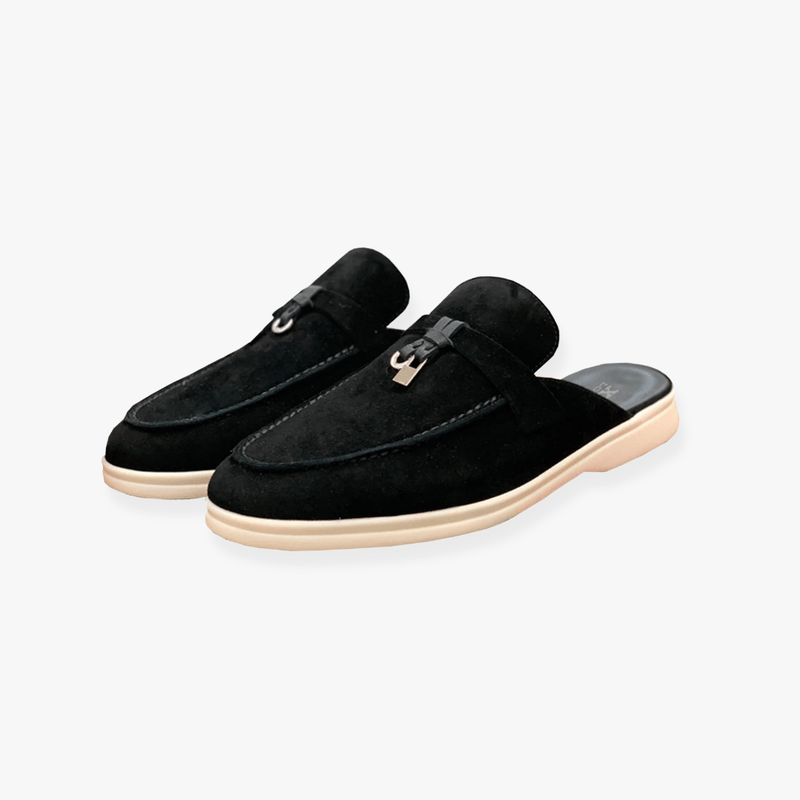 Female model in slip-on mule footwear on a plain background for casual styling.