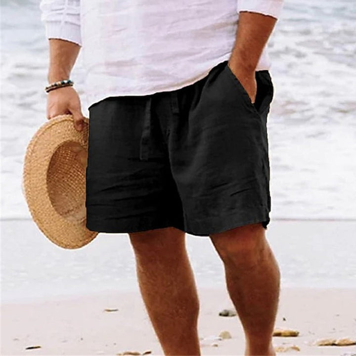  Men’s beach-style shorts with side pockets arranged on a plain background.
