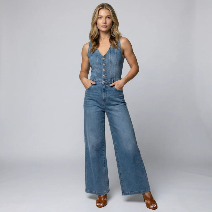 Female model wearing a sleeveless wide-leg denim jumpsuit on a plain background.