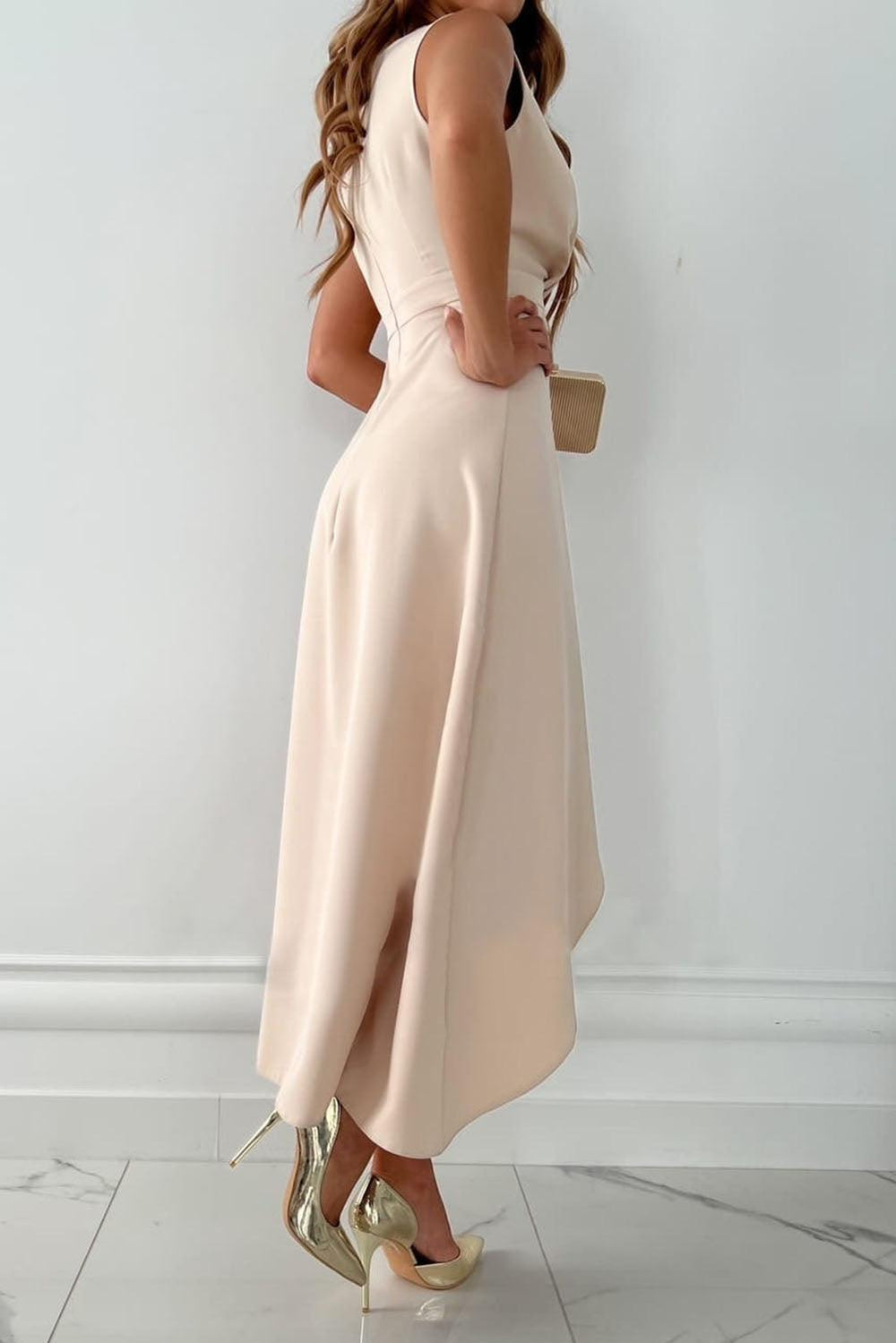 Female in a chic wrap dress with a V-neckline on a plain background.