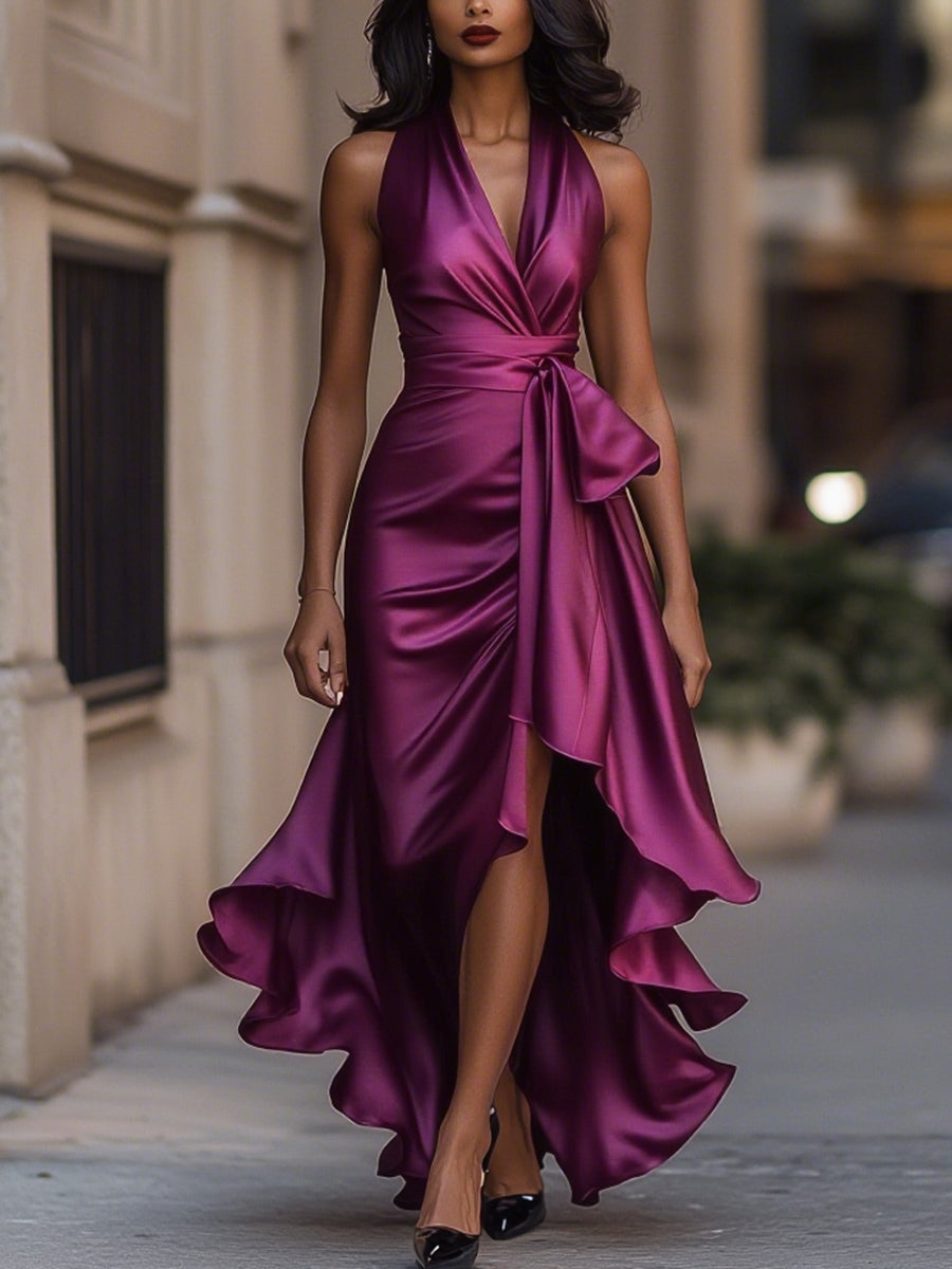 Model wearing a navy high-low gown with soft waist sash on a plain background.