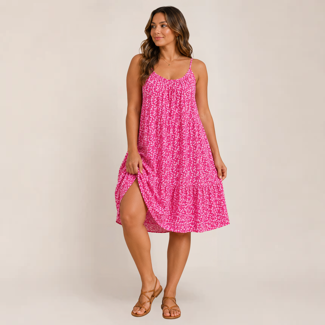 Female model wearing a flowy floral sundress with lightweight straps on a plain background.