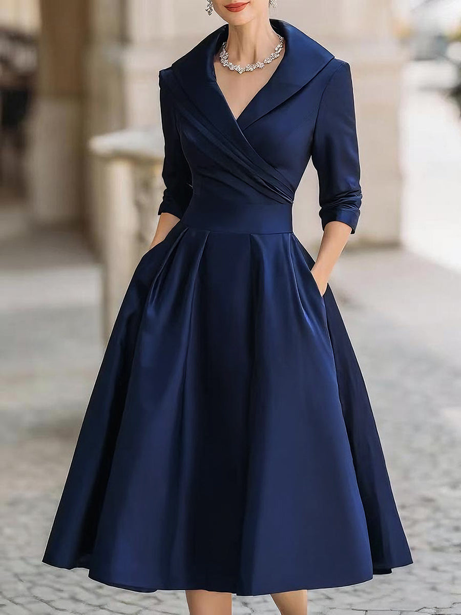 Model wearing an elegant midi dress with a shawl-style neckline against a plain background.