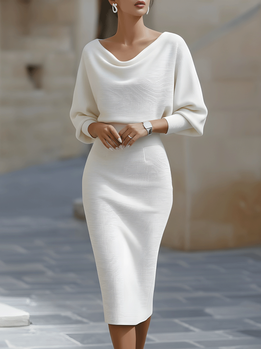 Woman in a white fitted midi dress with draped neckline and long sleeves on a plain background.