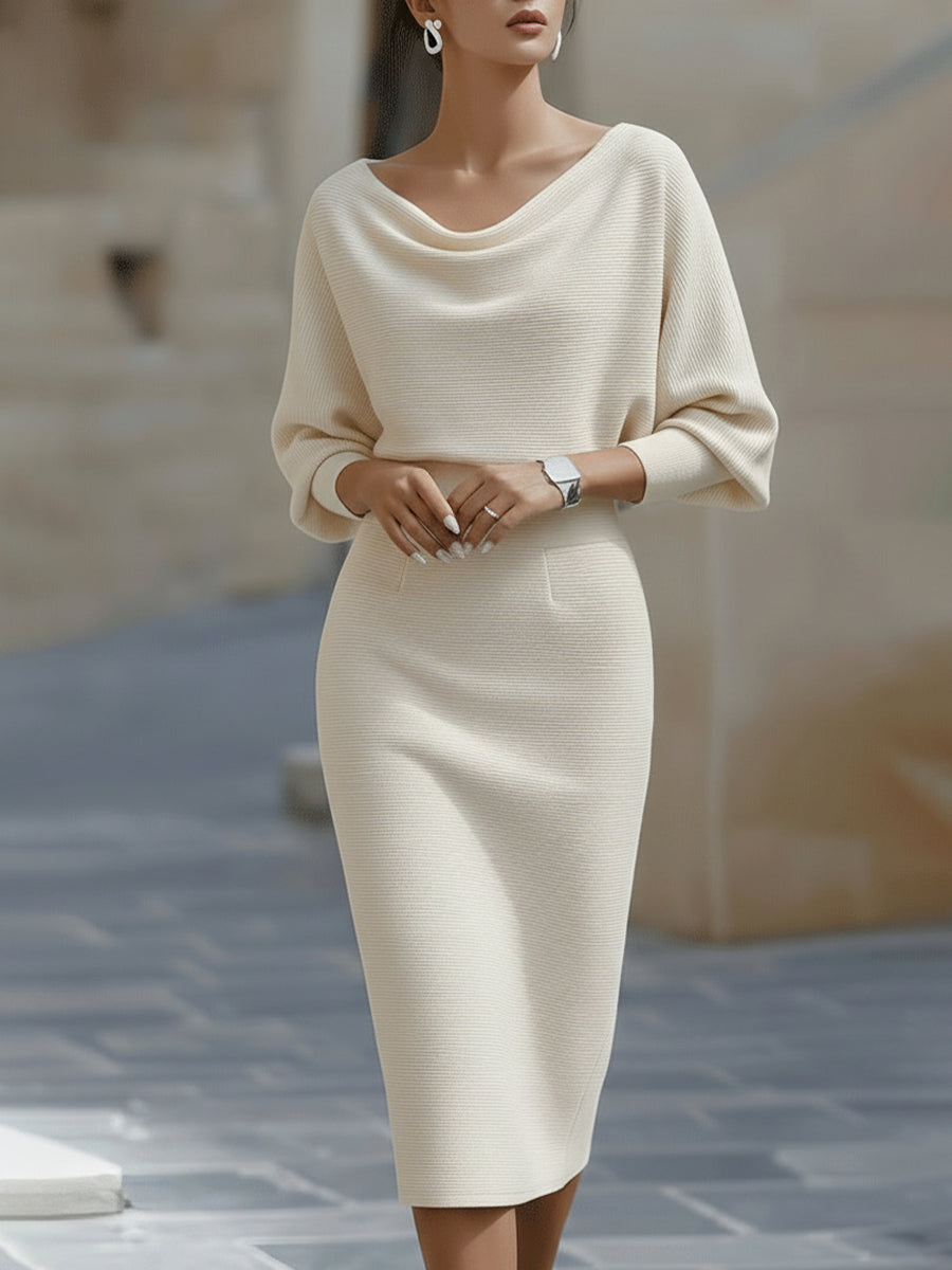 Model wearing a white long sleeve midi dress with slim skirt and relaxed upper drape on a plain background.